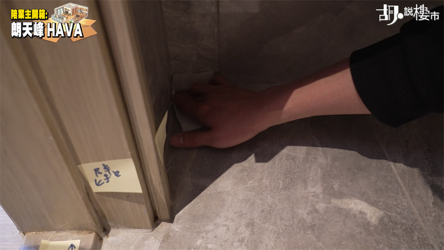 鍾 Sir 發現浴室櫃底的地磚縫隙有濕氣，用紙巾按壓後明顯變濕